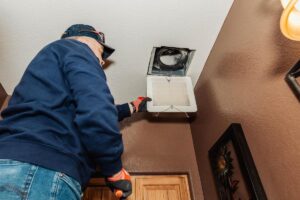 electrician troubleshooting a bathroom fan
